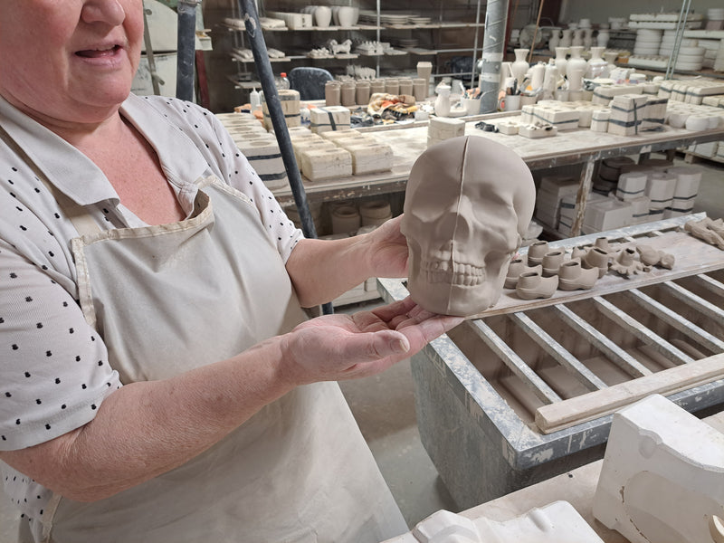 Our slipcaster showing a ceramic skull, just released from its mould.
