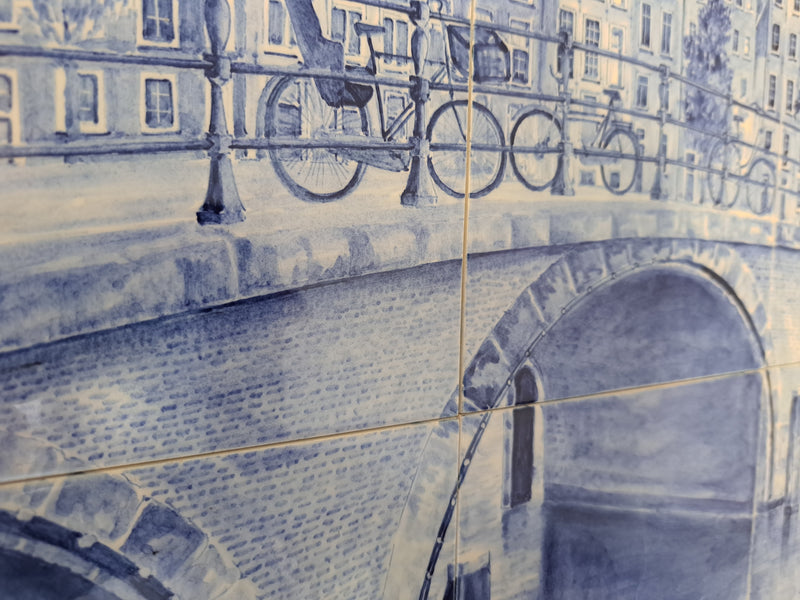 detail of a large delfttile panel with bicycles and a canal