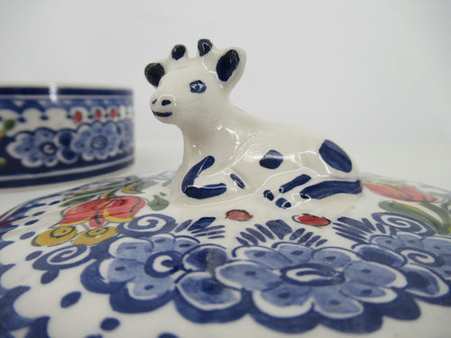 detail of the cowshaped lid, painted in delftblue and red tulip of a butterdish.