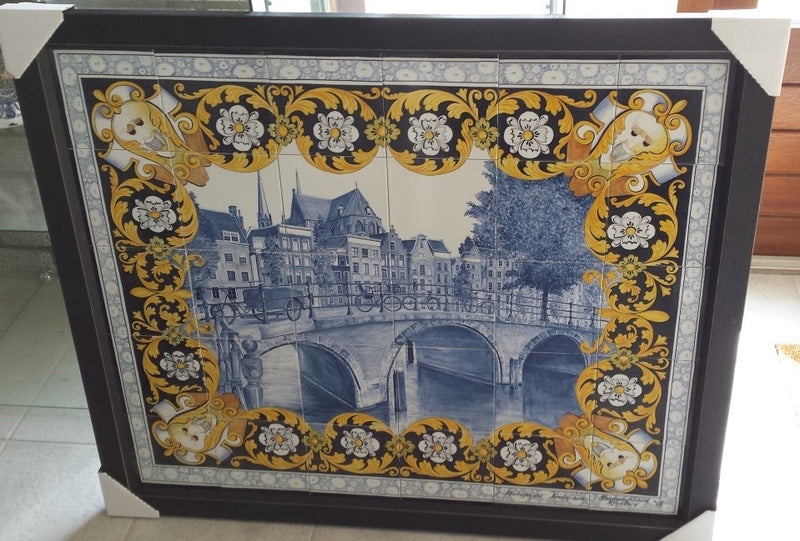 Framed Delftblue tilepanel depicting Dutch canal view with multicolor floral border