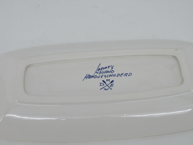 painters signatute on the back of a delftblue dish.