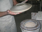 trowing a ceramic plate on yhe jigger.