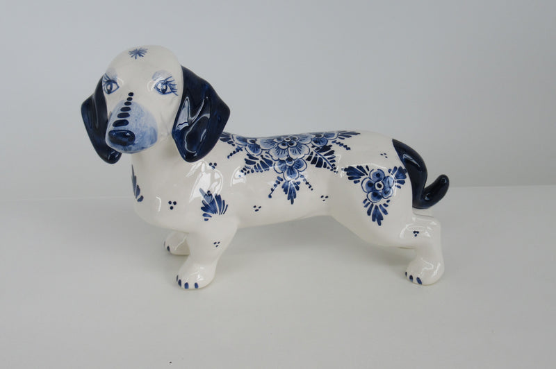 Delftpainter painting a deltblue ceramic dachshund at monyagne aardewerkfabriek