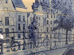 detail of a delfttile panel with bicycles and Amsterdam canal houses