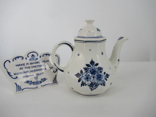  backside view of a delftblue teapot showing a floral delftbue pattern.