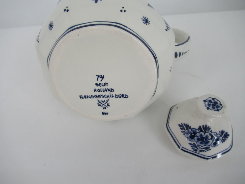  view of the bottom of a  delftblue teapot with brand mark and its painters signature.