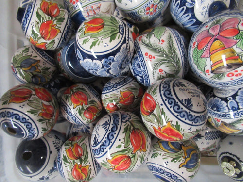 Grote doos vol met kerstballen van keramiek met geschilderd rode tulpdecor.