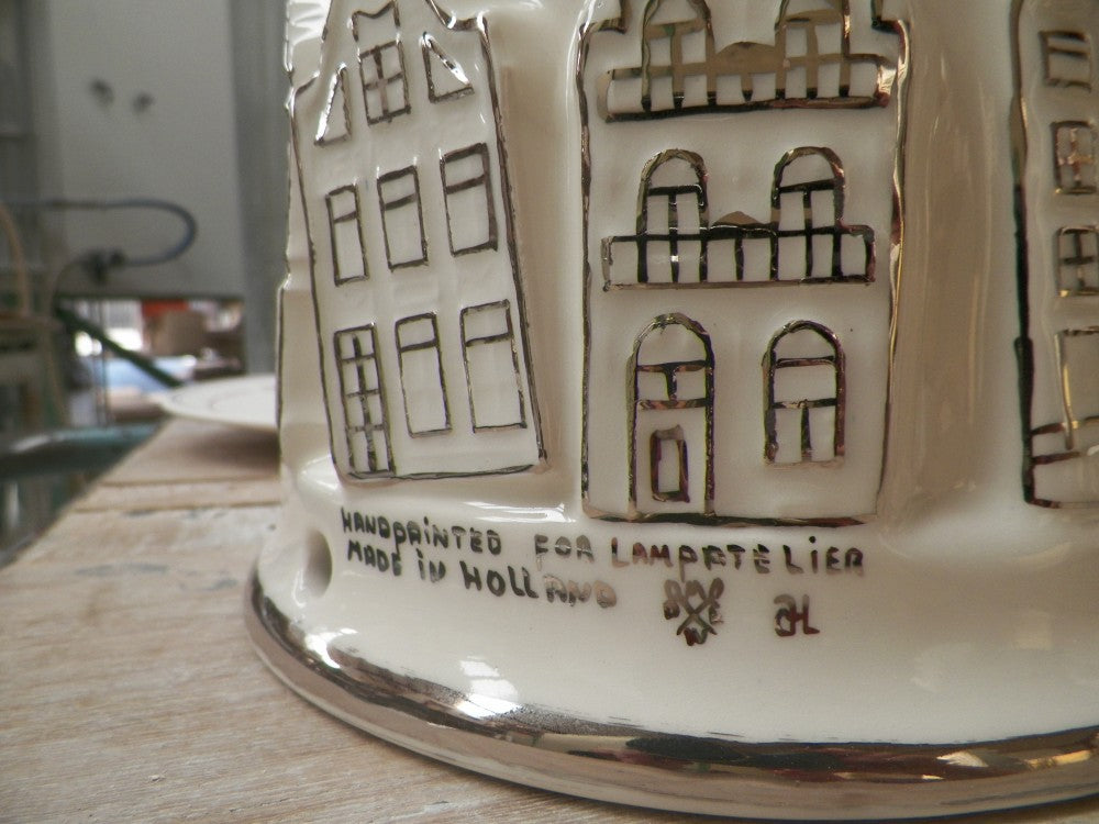 detail of a ceramic lampbase painted with silver canal houses.