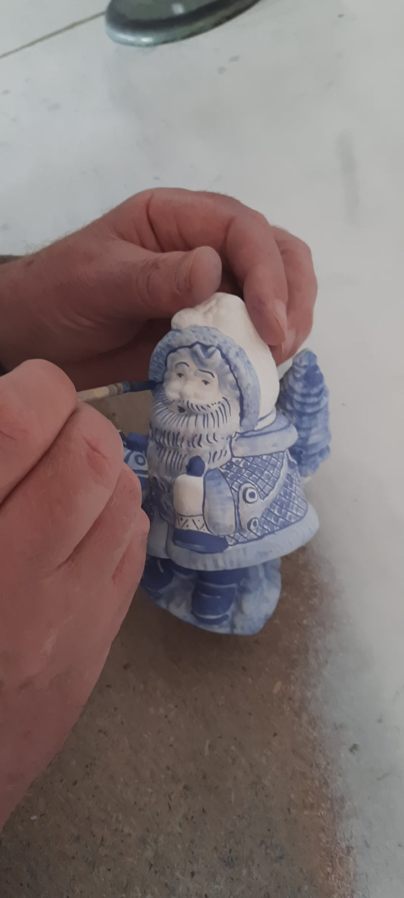 the painting is shown of a delftblue ceramic santa holding a train toy at Dutchceramics.