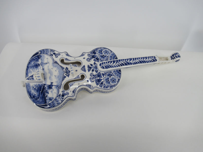 delftblue ceramic violin with a dutch windmill scene painted on it