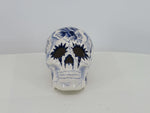 front of a delftblue ceramic skull with a tattoo design