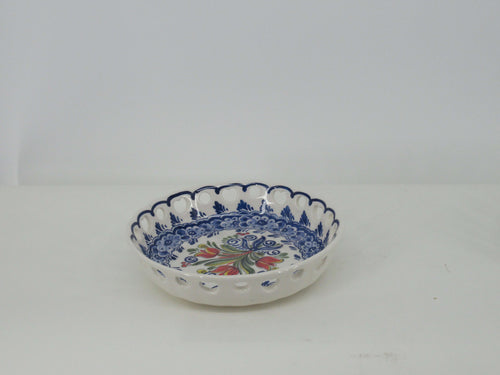 open delftblue ceramic dish with a bouquet of red tulips at the centre